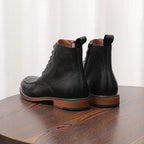 Pair of black leather side-zip dress boots with pointed toes and lace-up fronts