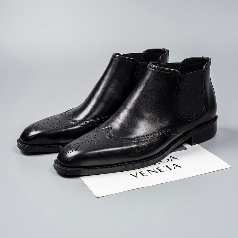 Black leather Chelsea dress boots with elastic gore, perforated toe, and low block heel