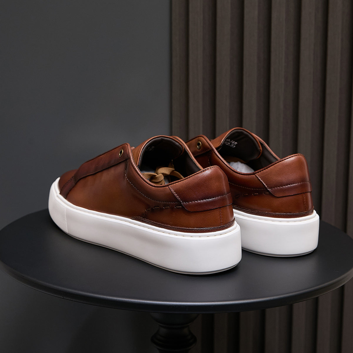Men's brown leather sneakers heel view with white platform sole
