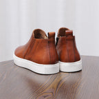 Brown leather pointed-toe dress boots with side zippers and white rubber soles