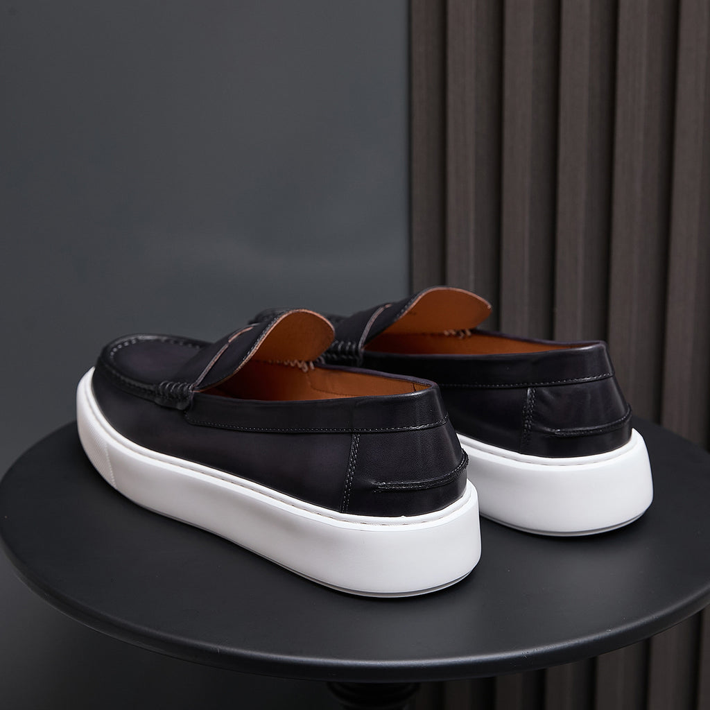 Back view of black leather slip-on sneakers with white platform sole