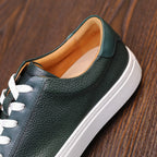 Green leather sneakers with white laces, tan interior lining, and textured rubber sole