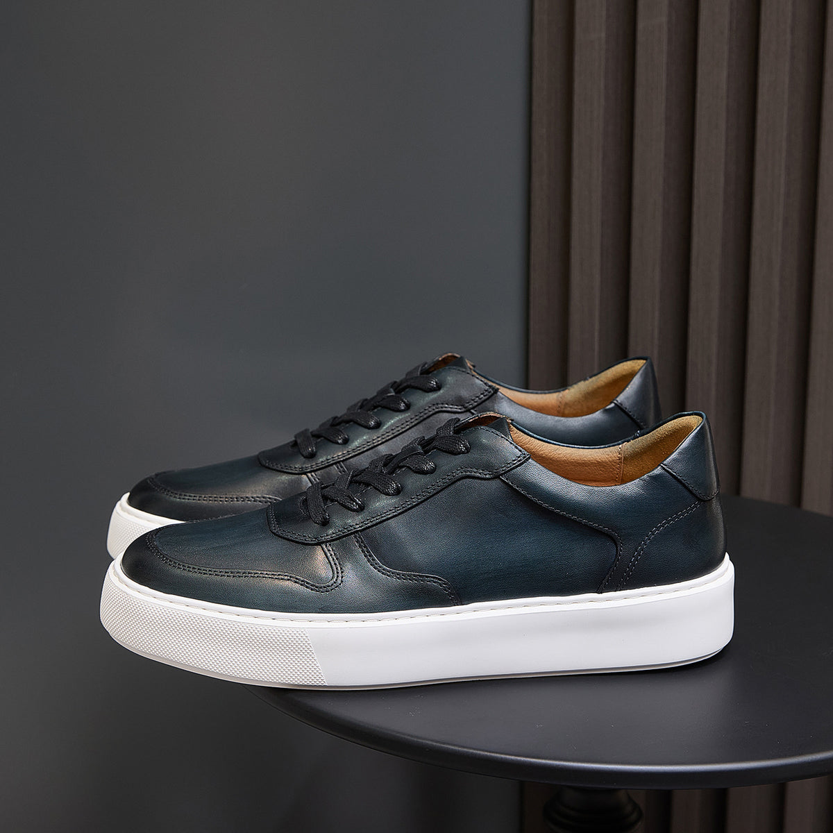Men's dark green leather sneakers with black laces and cushioned white sole platform