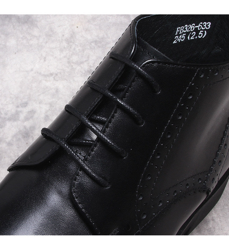 Black lace-up dress boots with wingtip perforations and textured leather upper