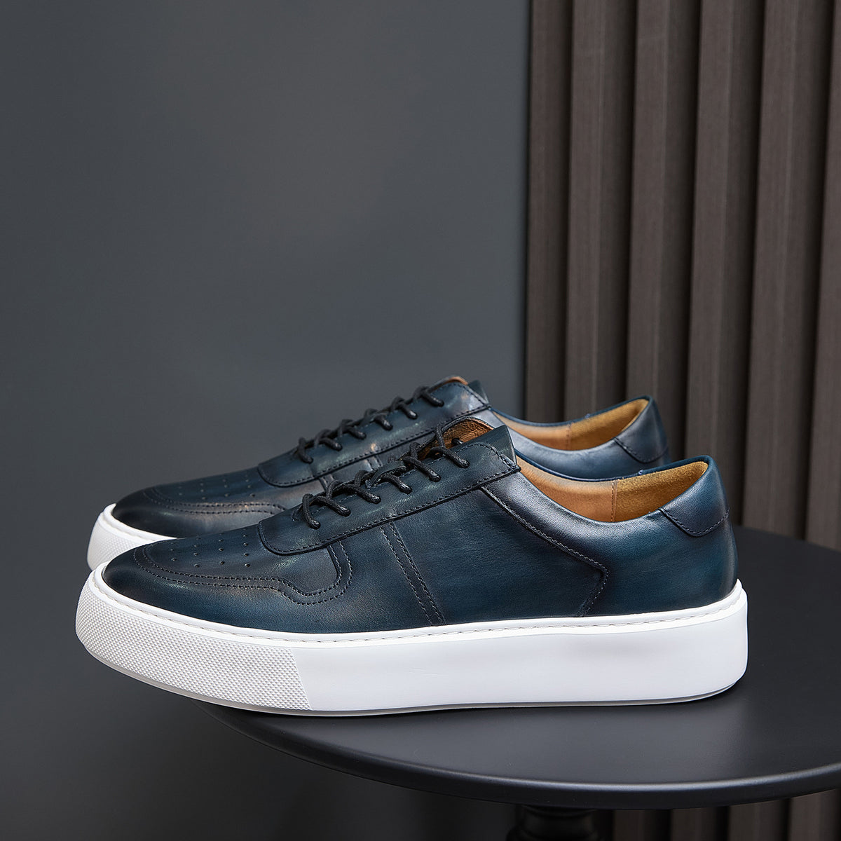 Leather sneakers, dark blue-green, lace-up front with white rubber sole.