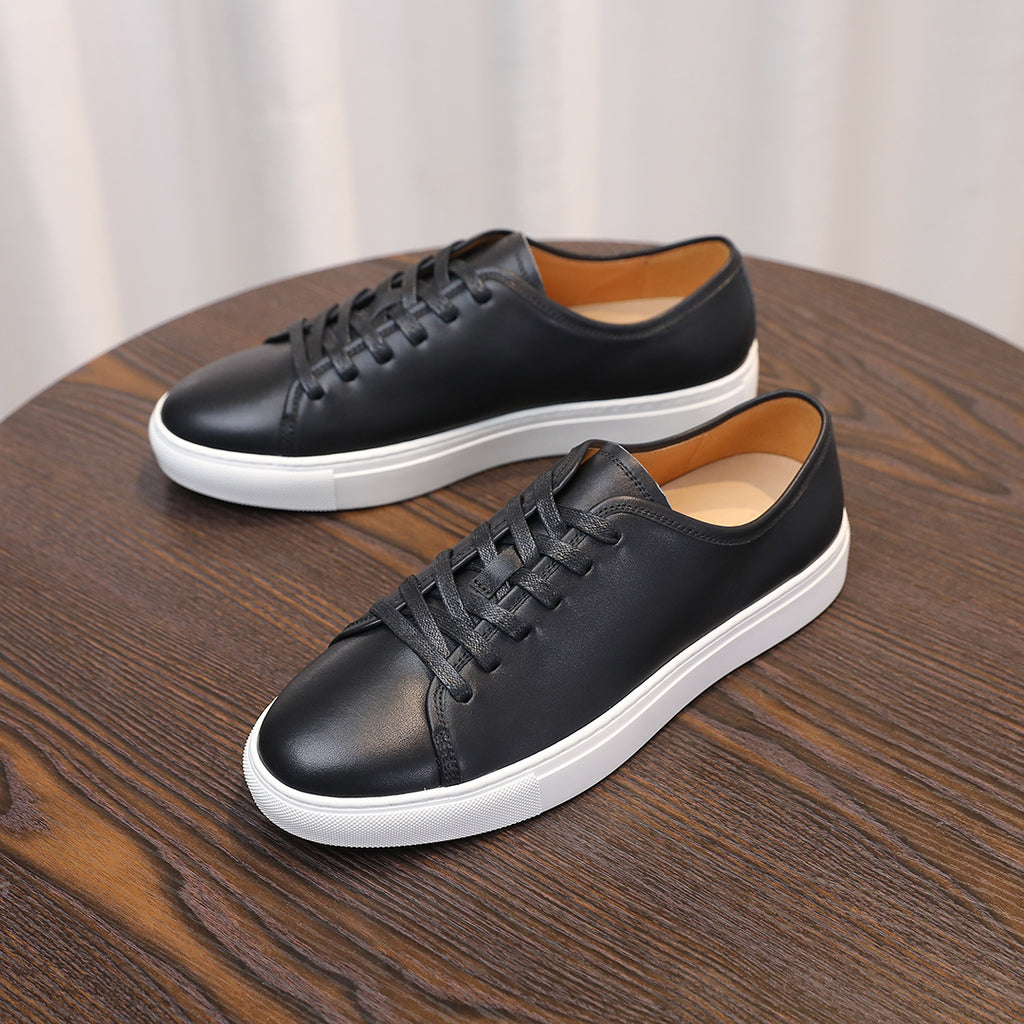 Men's leather sneakers, black low-top lace-up shoes with white midsole edge.