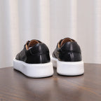 Men's black leather sneakers with white platform sole and lace-up design