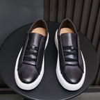 Black leather low-top sneakers with lace-up design and white rubber sole