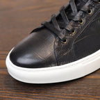 Men's black genuine leather sneakers, lace-up with low white rubber sole.