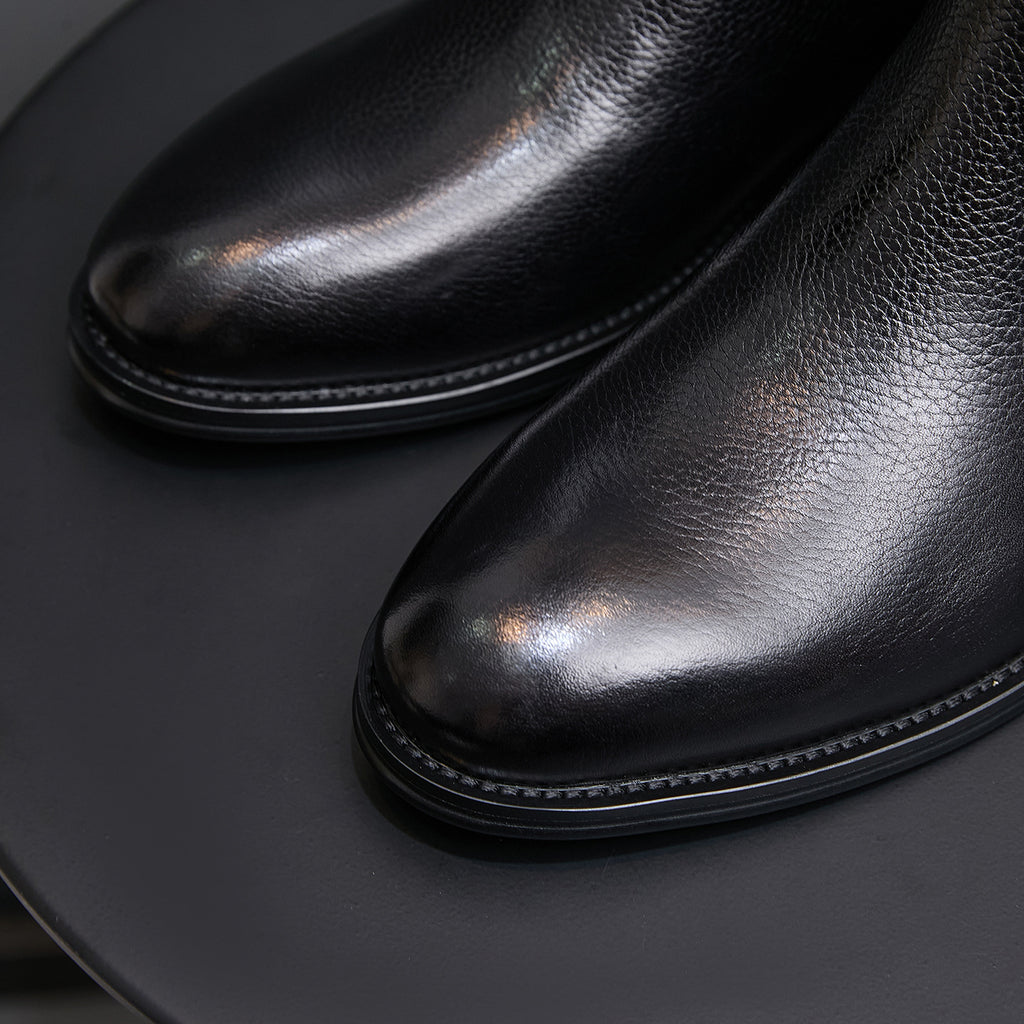 Pointed-toe Chelsea boots, black, close-up of smooth upper and stitched edge