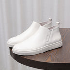 White leather pointed-cap toe side-zip dress boots with textured rubber sole