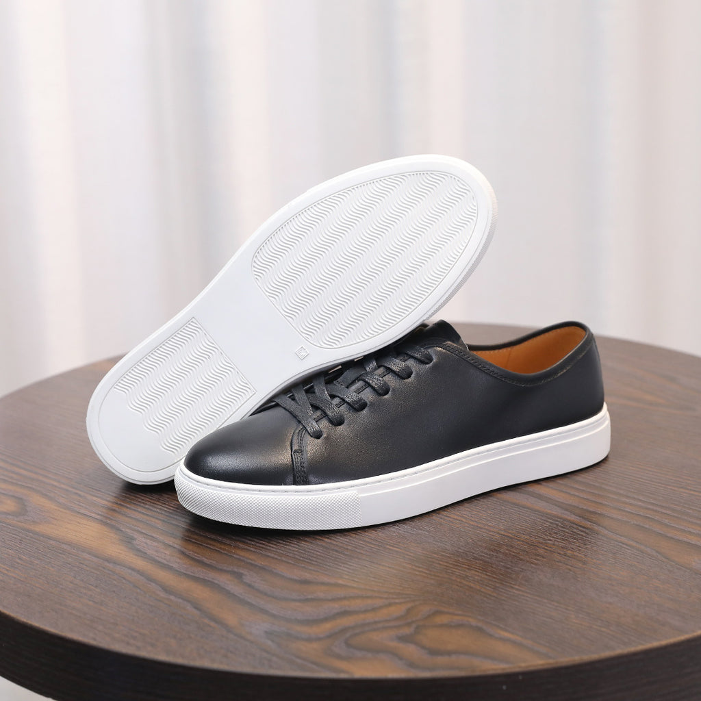 Black leather sneakers with white rubber sole and lace-up front.