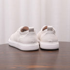 White leather low-top sneakers with lace-up front and thick white rubber sole