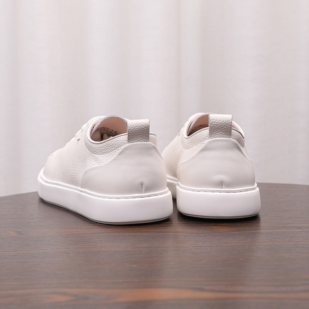 White leather low-top sneakers with lace-up front and thick white rubber sole