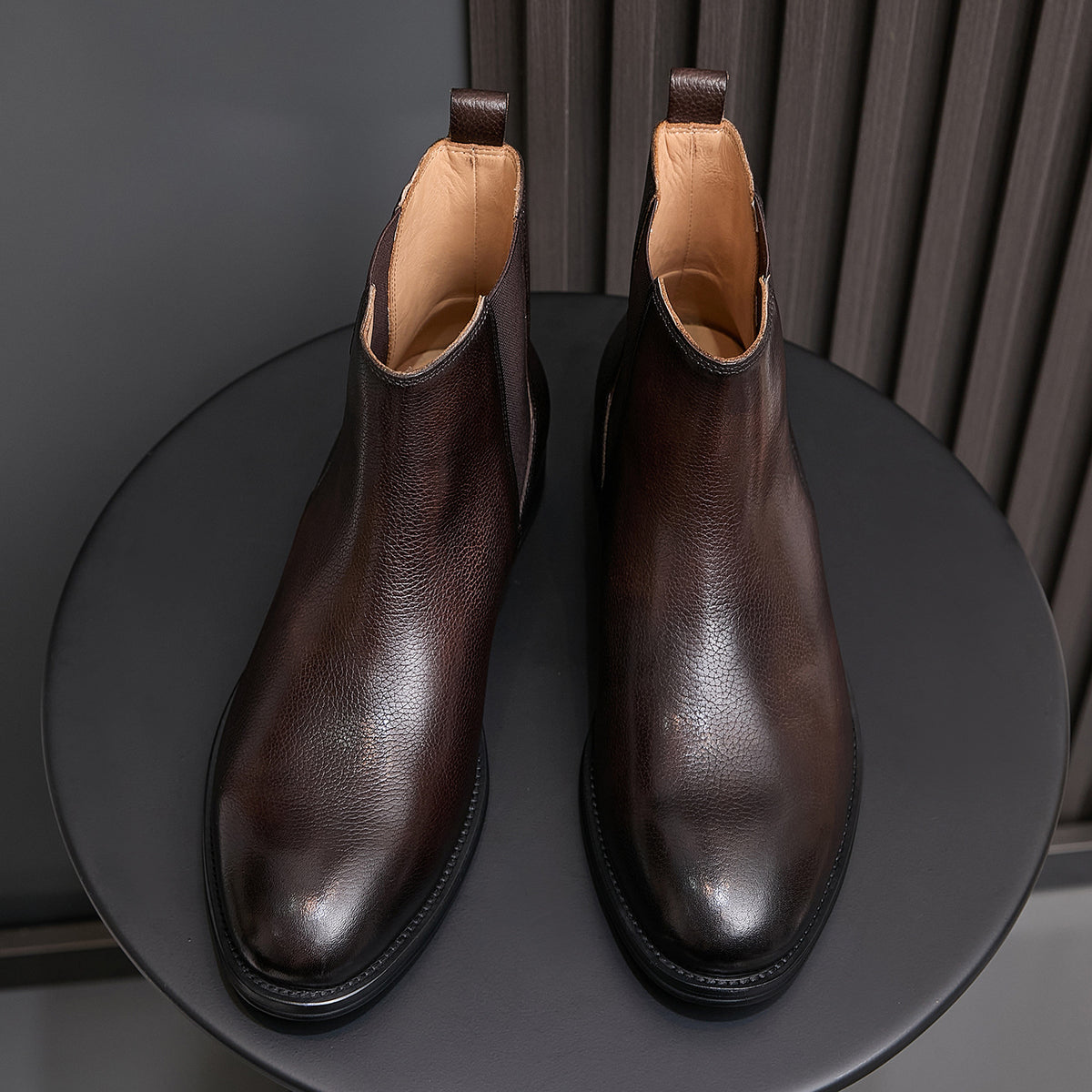 Pair of brown chelsea dress boots with elastic side panels and tan interior lining
