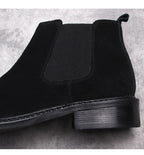 Men's black Chelsea dress boots, close-up of elastic gore and low stacked heel
