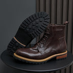 Dark brown leather cap-toe boots with side zip and lace-up; outsole tread visible