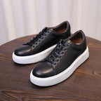Men's black leather sneakers with lace-up, perforated toe, and white platform sole