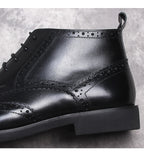 Black wingtip lace-up dress boots with stitched panels and padded collar