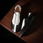 Black and white leather sneakers, angled view showing toe and side panel stitching.