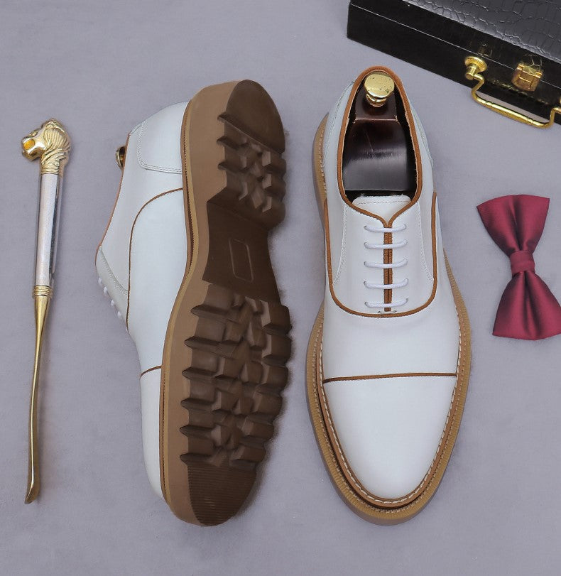 White lace-up oxford shoes with brogue/wingtip stitching and chunky lug sole.