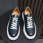 Blue leather low-top sneakers with white laces and white rubber sole