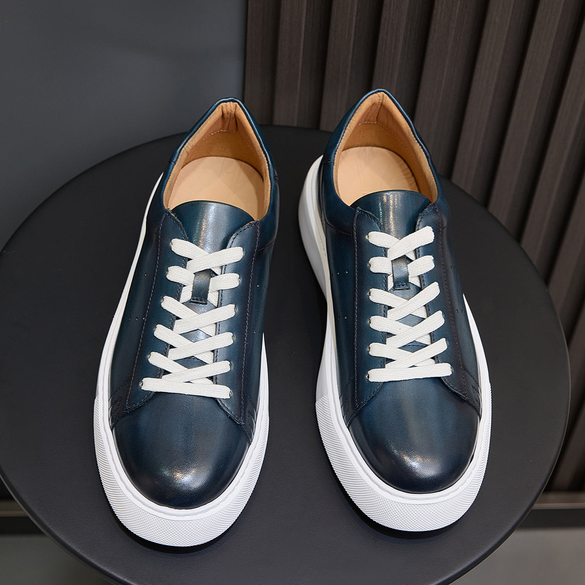 Blue leather low-top sneakers with white laces and white rubber sole