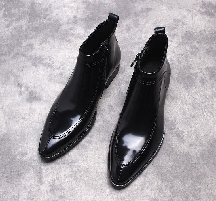 Black leather side-zip dress boots with pointed toe and stitched paneling