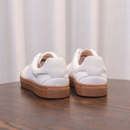 White genuine leather low-top sneakers with lace-up and tan rubber sole, heel detail