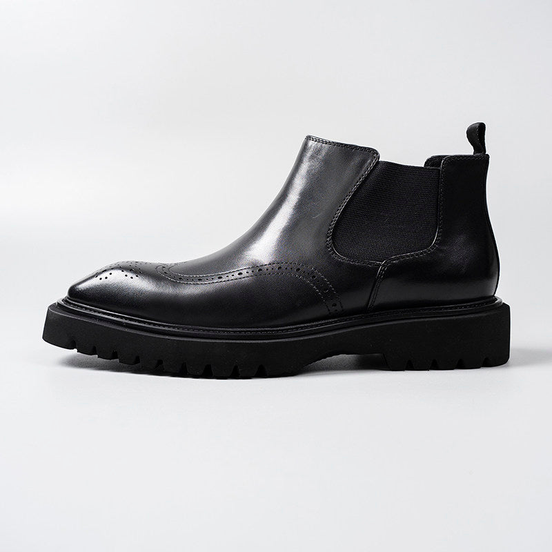Black leather Chelsea dress boot profile with elastic gore, perforations, and tread sole