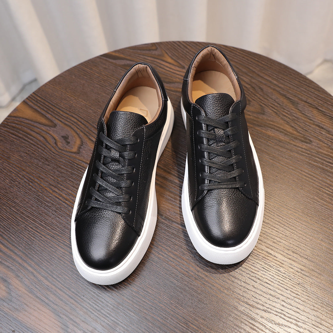 Black leather sneakers shown front view with lace-up design and white soles.
