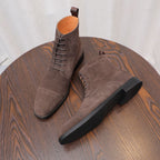 Dark brown suede chukka boots, side angle view with lace-up closure and black sole