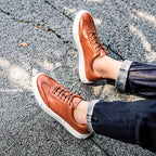 Brown leather lace-up sneakers with white rubber sole and textured outsole