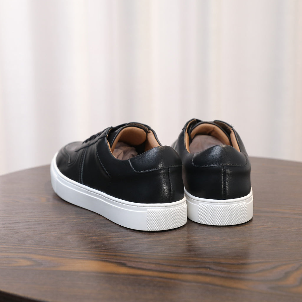 Men's black leather sneakers from the heel, showing cushioned collar and white sole