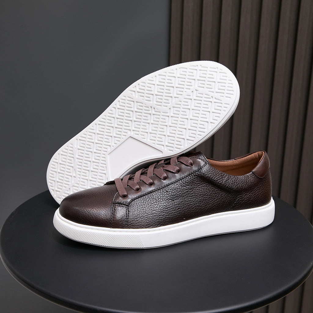 Dark brown leather sneakers with white outsole tread and lace-up upper