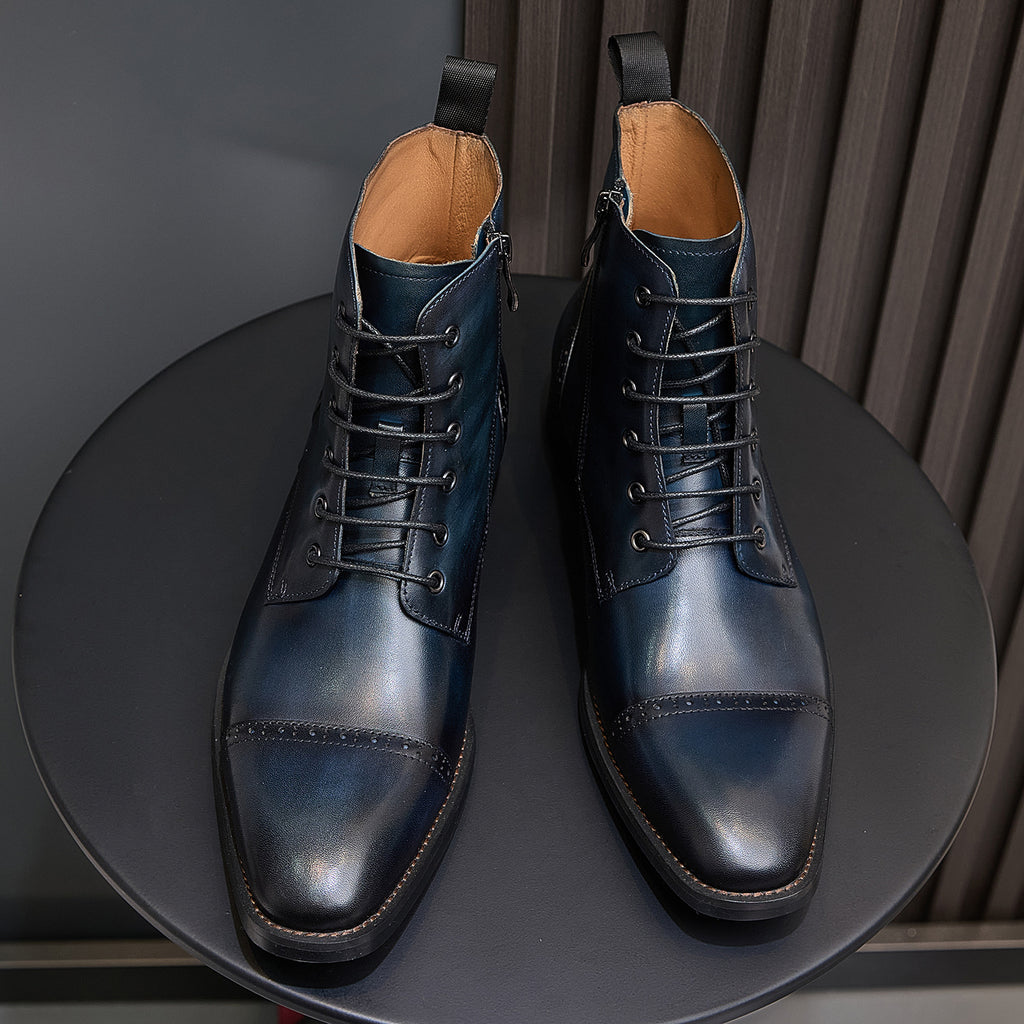 Two lace-up leather ankle boots with dark blue finish, pointed toe and tan lining.