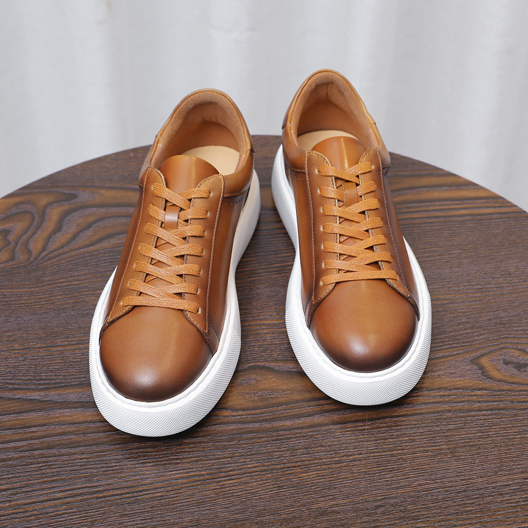 Men's brown leather lace-up sneakers, two shoes front view with white soles