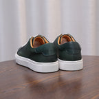 Back view of green leather sneakers with padded heel and white rubber sole