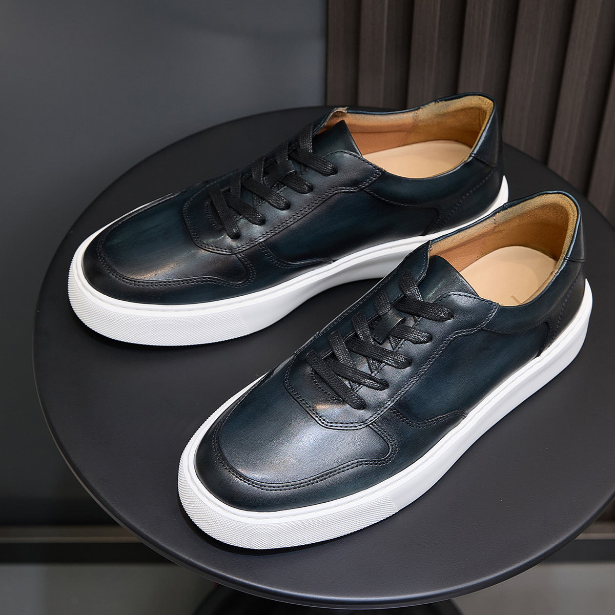 Men's leather sneakers, dark blue pair view with low-profile white rubber sole.