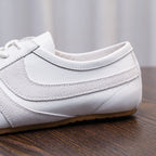 Men's white leather sneaker with stitched panels, lace eyelets, and padded collar