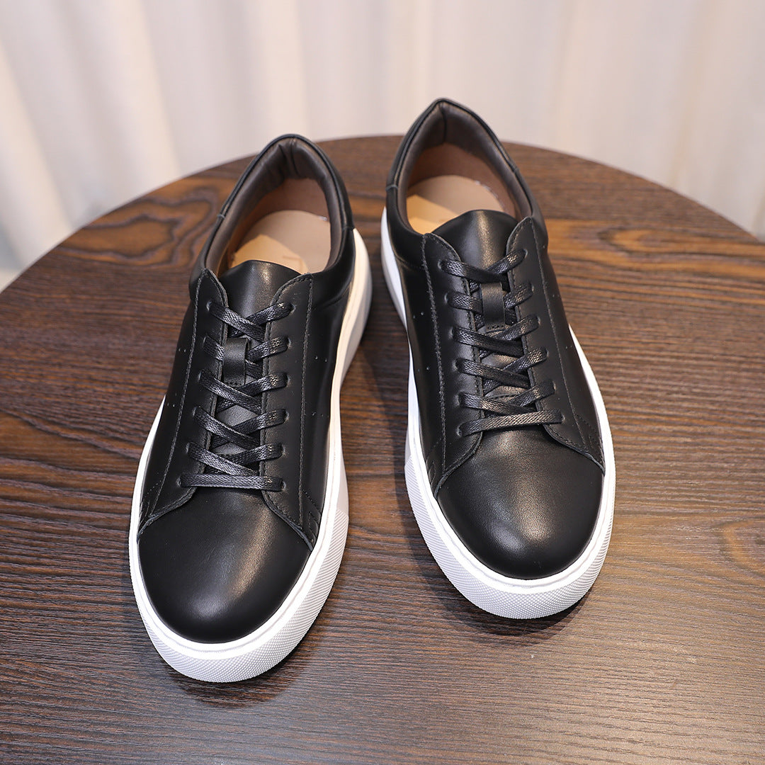 Pair of men's black leather sneakers with lace-up front and white rubber sidewalls