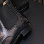 Close-up of men's black chelsea boot heel and elastic side panel with stitched edge