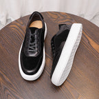Black leather lace-up sneakers with white rubber sole and low-profile side panels