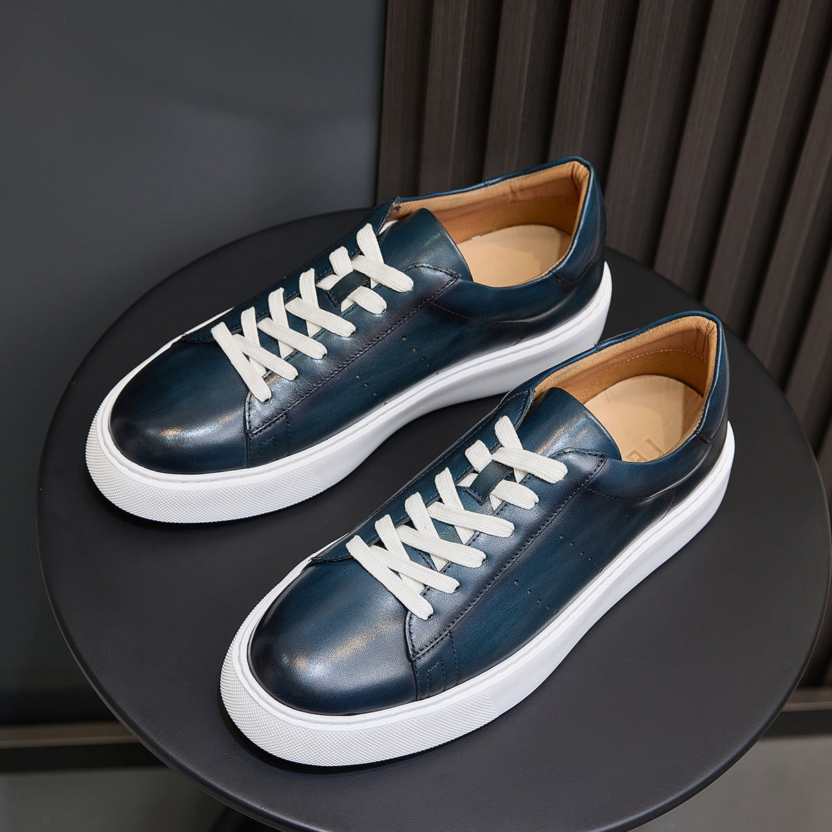 Pair of blue leather low-top sneakers with white laces and side panels