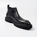 Black leather Chelsea dress boot with elastic side panel and brogue-style perforations