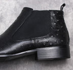 Black leather Chelsea boots close-up of elastic gore and textured leather