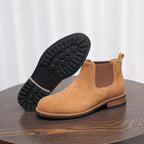 Tan suede Chelsea boot showing black treaded outsole and elastic side gore.