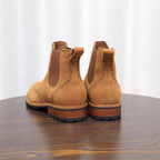 Back view of brown suede pointed-toe Chelsea boots with stacked heel and tread sole