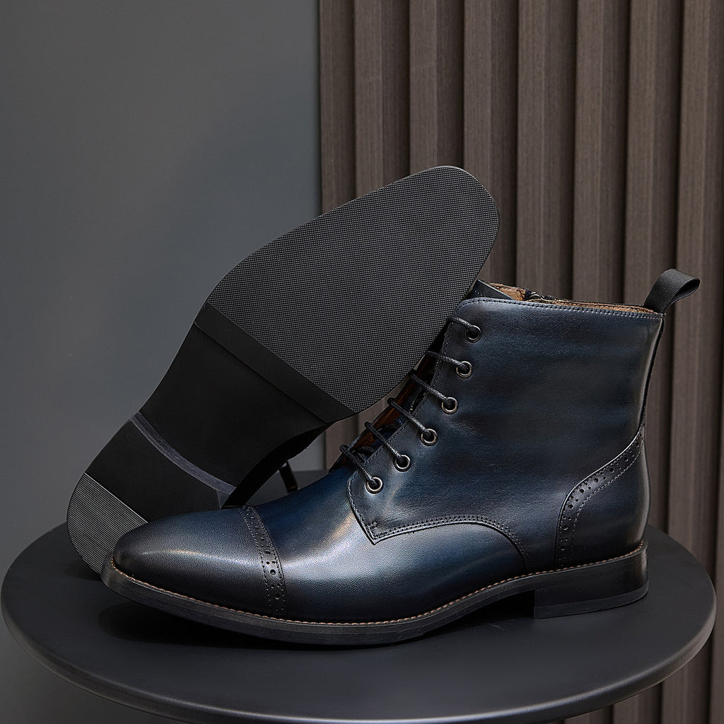 Lace-up leather boot with side zipper pull tab and dark rubber sole, dark blue.