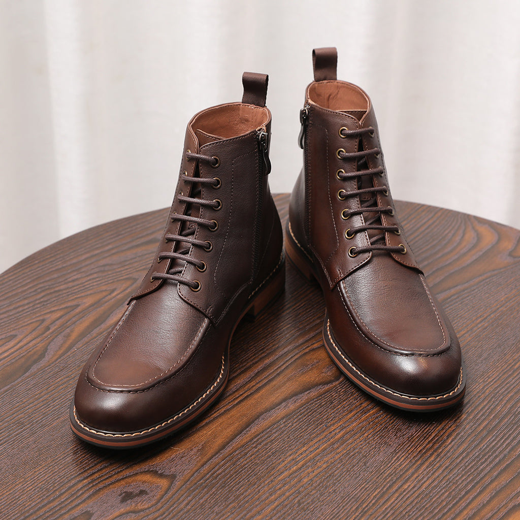 Two brown leather lace-up ankle boots with pointed toes and stitched rubber sole